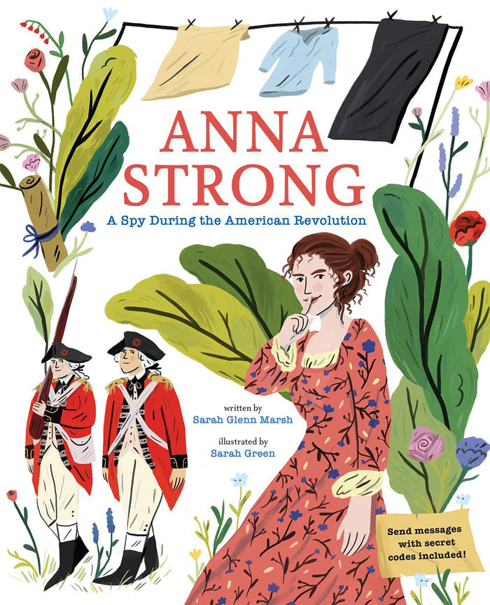 The cover of Anna Strong: A Spy During the American Revolution shows a woman in a red period dress holding a finger to her lips in a quiet “shh” gesture. To one side, two British soldiers stand nearby, while above her a clothesline with garments hangs as a subtle nod to secret spy signals. The scene is framed by lush, colorful foliage in greens, pinks, reds, and blues.