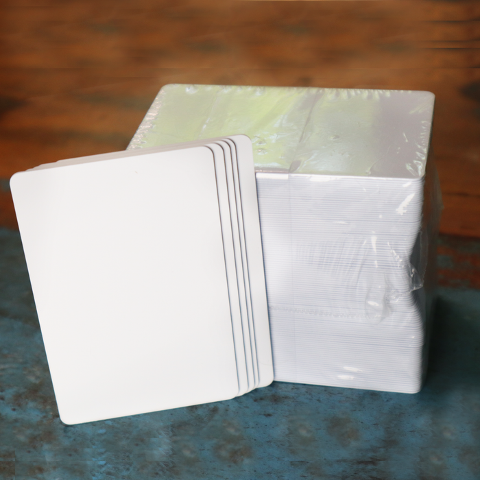 Blank white composite PVC/PET cards on wood surface