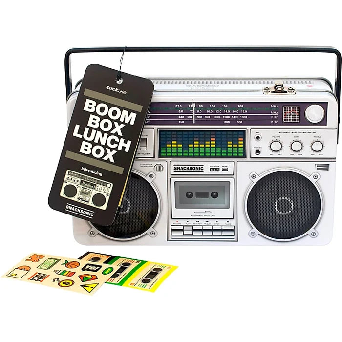 White‑silver lunch box with a black hangtag reading “BOOM BOX LUNCH BOX” in white block letters; front of the shows a retro white boombox with black speakers, knobs, a cassette deck, and a small “SMACKSONIC” label.