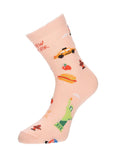 The image shows the peach/beige NYC Cartoon Icon Sock displayed on a mannequin foot. The sock is decorated with playful, colorful illustrations of New York City favorites, including the Statue of Liberty, yellow taxis, hot dogs, fire hydrants, and other iconic city symbols, as shown in the previous image.