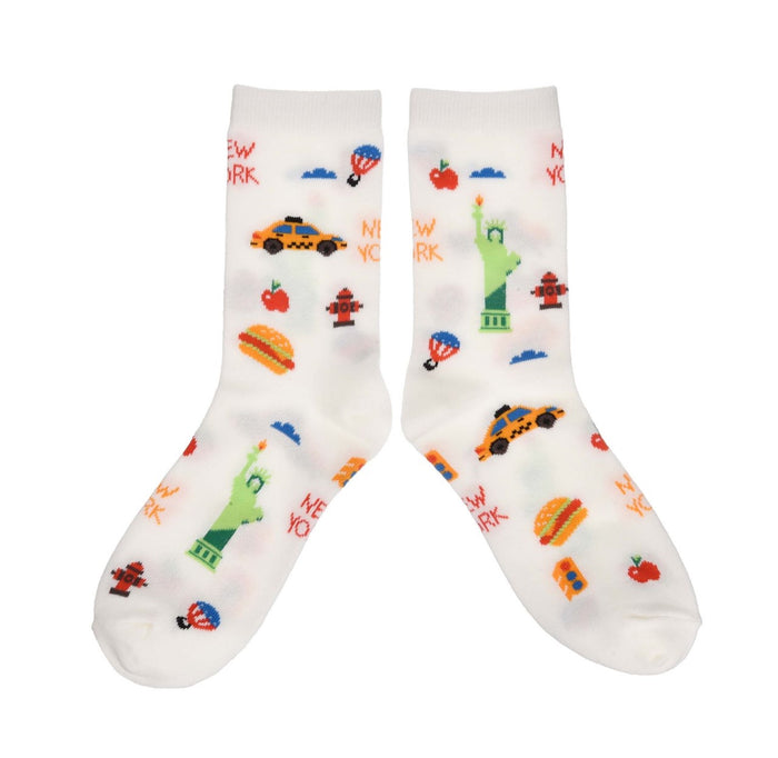 Featured against a white background, a pair of  white NYC Cartoon Icon Socks decorated with colorfully playful illustrations of New York City favorites, including the Statue of Liberty, yellow taxis, hot dogs, fire hydrants, and other iconic city symbols. The colorful, cartoon-style design creates a fun and lively celebration of New York.