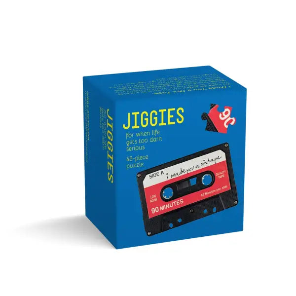 Title: Jiggies. The box shows the title in bright yellow lettering on a blue background, with the subtitle for when life gets too darn serious and a note that it’s a 45‑piece puzzle. The lower half displays a retro black cassette with white and red details.
