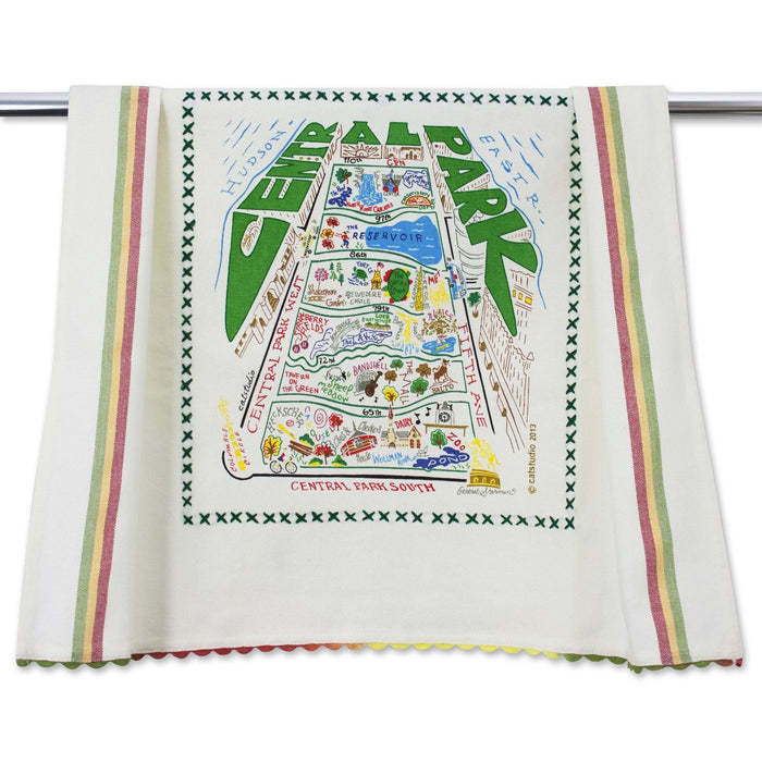 The image shows the Central Park Dish Towel displayed flat against a white background. The towel features a colorful illustrated map-style design highlighting iconic Central Park landmarks, pathways, lakes, bridges, monuments, and recreational areas. Bright greens, blues, and warm accent colors create a lively, hand-drawn look, celebrating the park’s natural beauty and beloved attractions in the heart of New York City.