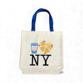 A large natural‑colored recycled‑cotton tote featuring a playful illustration of a classic New York breakfast: a blue‑and‑white Greek‑style coffee cup and a bacon, egg, and cheese sandwich on a speckled round yellow roll. The bag is roomy with a flat bottom, long shoulder blue straps, and is designed for everyday carrying. It measures 16 inches wide by 15.5 inches tall, has a 6‑inch gusset, and is machine washable in cold water.