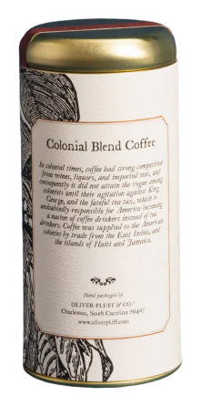The image shows a tall, upright coffee canister with a smooth matte gold finish and a round, re‑sealable gold lid, holding 5 ounces of roasted ground coffee. The cylindrical metal tin is wrapped in an 18th‑century–inspired label and includes a brief note on the back about coffee’s rise as a patriotic alternative to tea. Historic artwork and a refined color palette evoke early America while keeping the design clean, tactile, and display‑worthy.