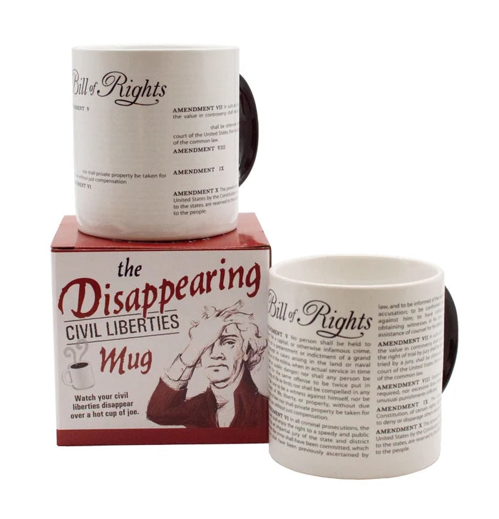 The image shows two views of The Disappearing Civil Liberties Mug alongside its box, displayed on a white background. One view shows the white ceramic mug printed with the text of the Bill of Rights, while the packaging is labeled “The Disappearing Civil Liberties Mug” and appears to feature an illustration of George Washington slapping his forehead in exasperation.