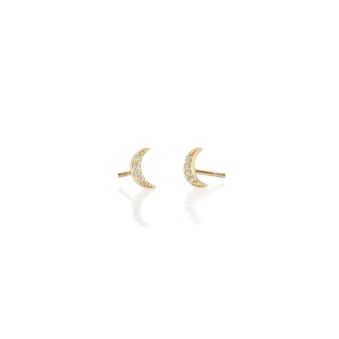 A matching pair of petite crescent moon stud earrings, each covered in tiny sparkling clear crystals. Delicate and lightweight, they have a celestial look with a subtle shimmer and are about the size of a small pencil eraser.
