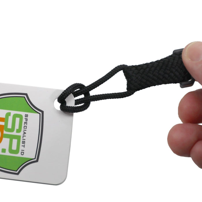A hand is holding an EK Lanyard Plus with Detachable Soft End (10252) by EK USA attached to a white badge with a green and orange Specialist ID logo, perfect for an outdoor lifestyle.