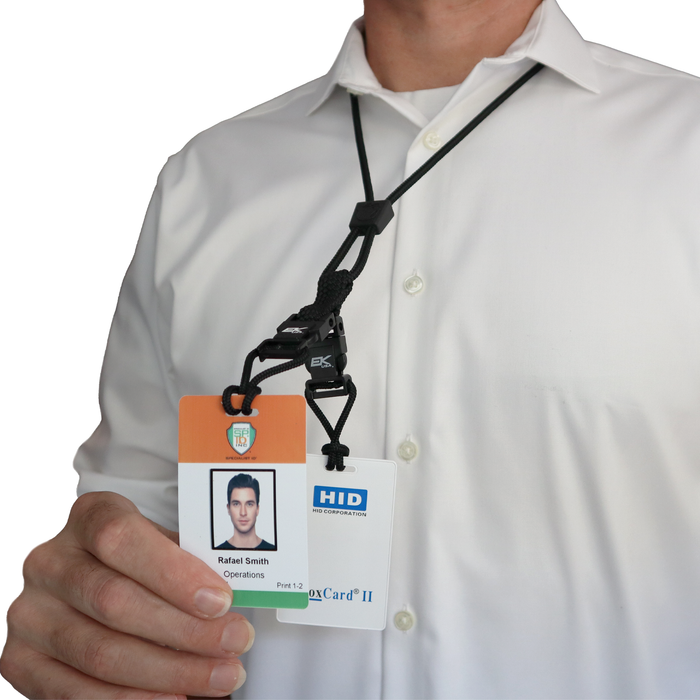 A person in a white shirt holds an ID badge featuring both a photo and text, attached to the Black EK Lanyard Plus II with Two Detachable Soft End Loops (10760) by EK USA. Sold by Specialist ID.