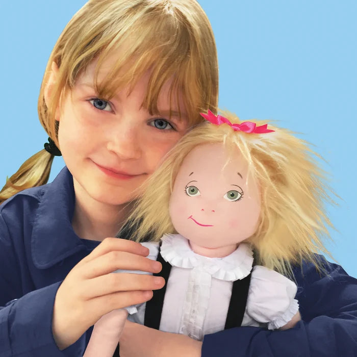 The image shows a smiling young girl with a ponytail holding the 18‑inch Eloise doll, playfully mirroring the doll’s cheerful, mischievous expression.