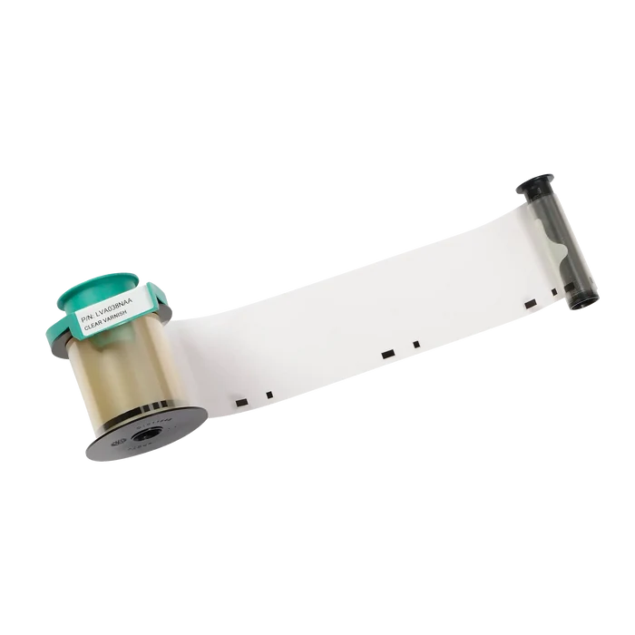A roll of transparent plastic film with a green label and black markings, partially unrolled, perfect for use in ID card printers as the Evolis LVA038NAA Clear Varnish Ribbon - 1200 Prints, Compatible with Primacy2 and Avansia Lamination includes an essential protective layer for ID cards.