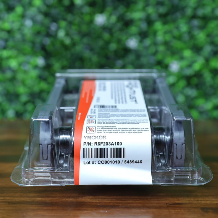Angled front-right view of the Evolis R6F203A100 YMCKO-K ribbon in sealed packaging, showing the white product label with part number, lot number, and YMCKOK panel designation. Photographed and sold by Specialist ID, an authorized Evolis dealer.