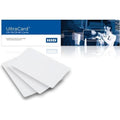 A package labeled "UltraCard CR-79/CR-80 Cards" featuring three blank white PVC cards in the foreground and an image of people exchanging FARGO 82266 CR-80, 10mil Blank White PVC Cards with Paper Adhesive Back in the background.