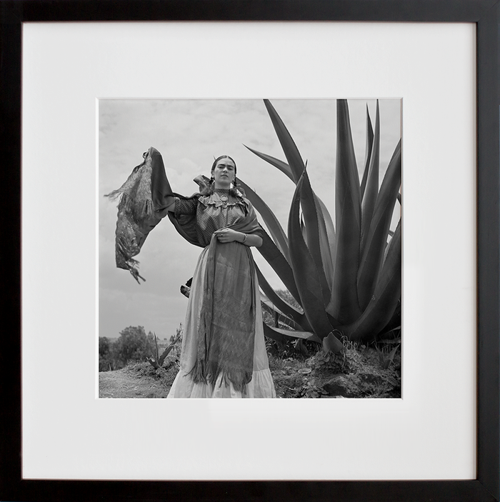 Frida Kahlo standing next to an agave plant