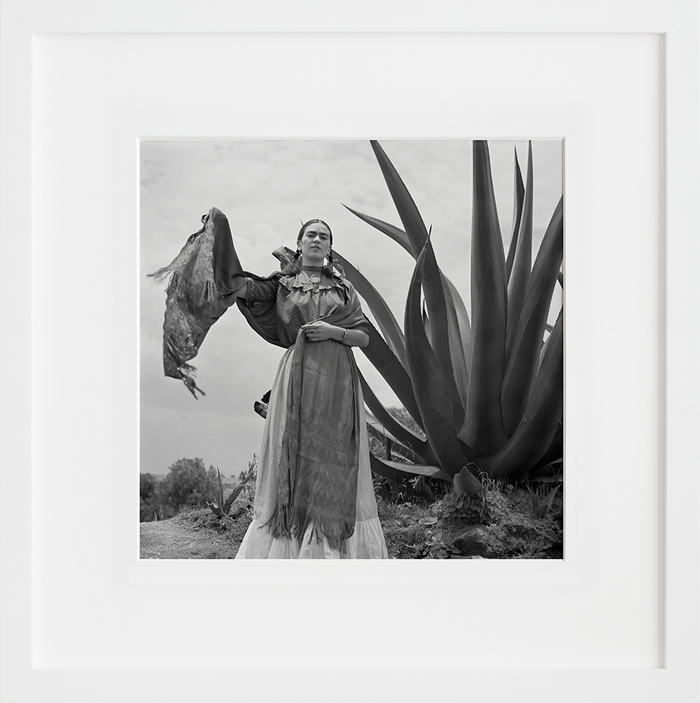 Frida Kahlo standing next to an agave plant