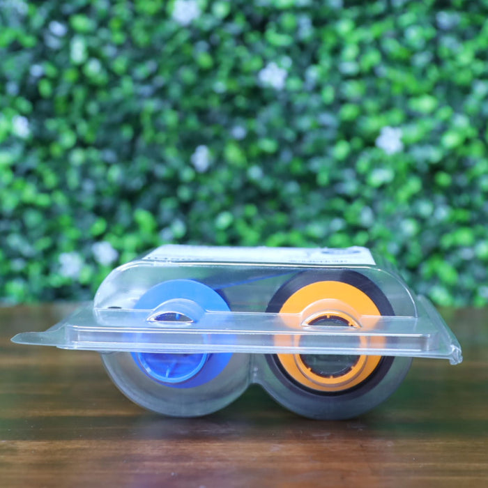 Bottom view of HID Fargo 045610 YMCKO Color Ribbon cartridge in sealed clamshell packaging, showing orange and blue spool hubs. Photographed and sold by Specialist ID, an authorized Fargo dealer.