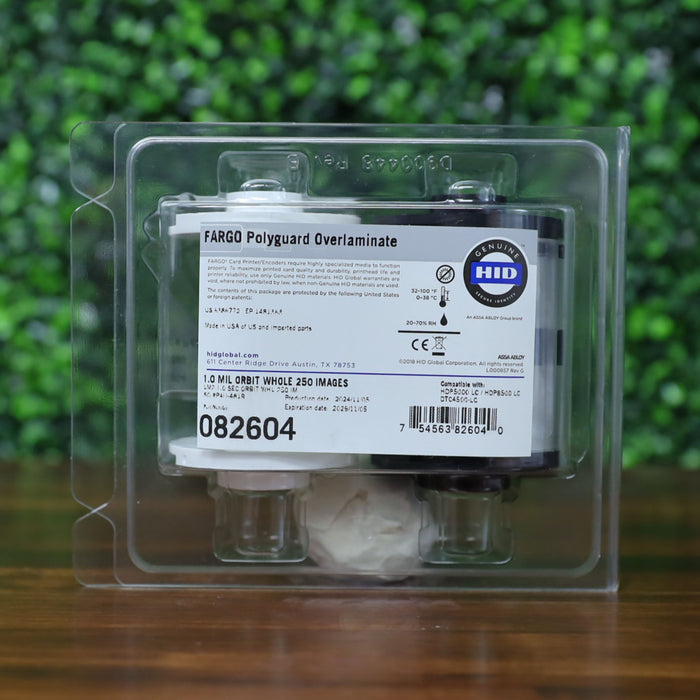 Close-up of Fargo 82604 PolyGuard holographic overlaminate cartridge in retail clamshell packaging, showing product label and compatibility details. Photographed and sold by Specialist ID, an authorized Fargo dealer.