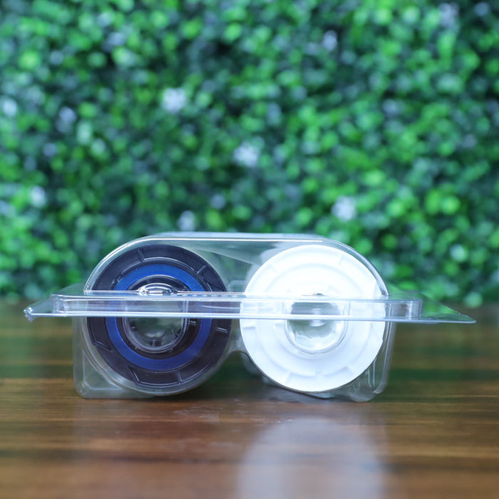 Side view of Fargo 82603 PolyGuard laminate inside transparent clamshell case, showing black and white supply rollers. Photographed and sold by Specialist ID, an authorized Fargo dealer.