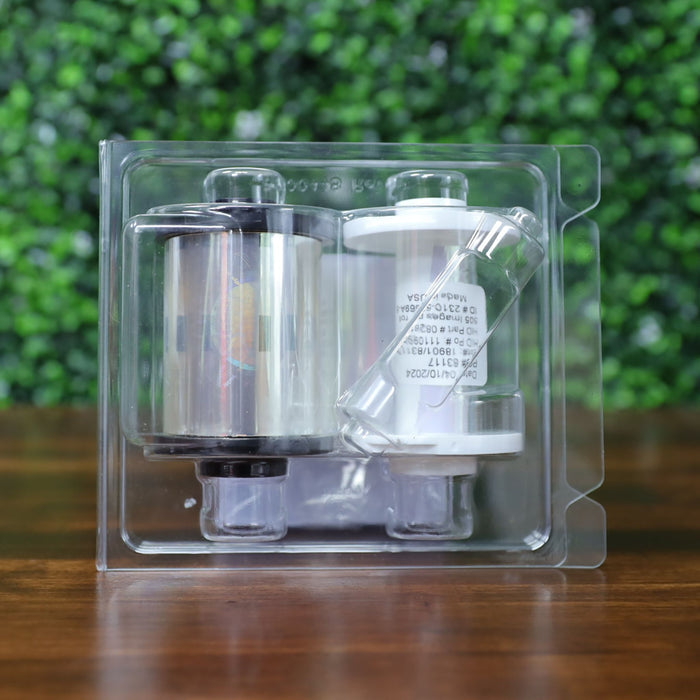Back view of HID Fargo 82618 holographic overlaminate inside sealed retail clamshell showing ribbon spools, secure orbit design shimmer, and included core inserts. Photographed and sold by Specialist ID, an authorized HID Fargo dealer.