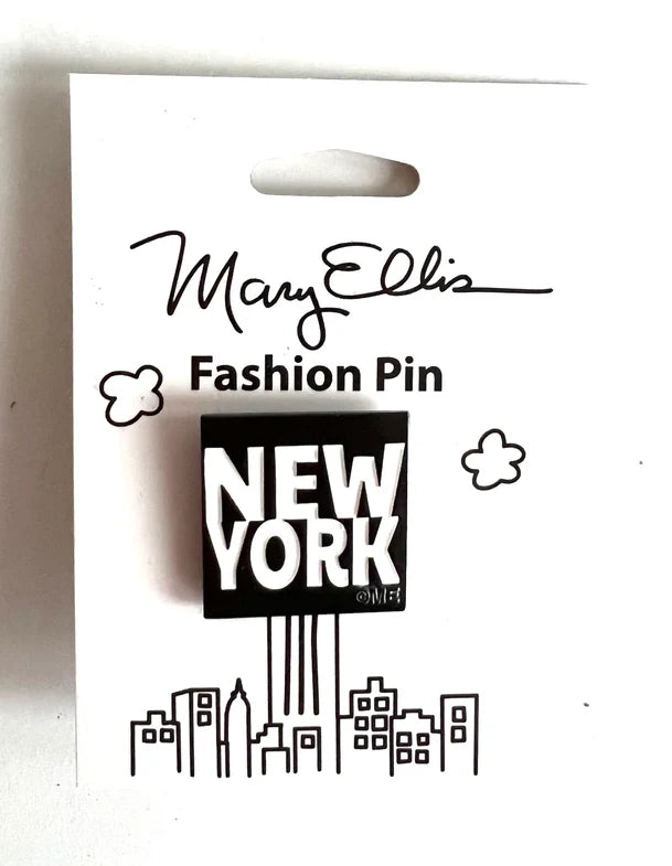NEW YORK PIN:
Set against a bold black background, the pin features bright white, all‑caps text reading “NEW YORK” centered prominently in a clean, high‑contrast design. The style is simple, playful, and minimalist, relying on strong typography rather than imagery. The pin is displayed on crisp white illustrated packaging, which highlights the striking contrast and lets the text‑based design stand out clearly.