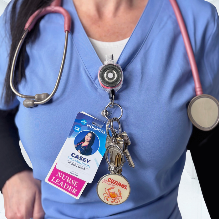 Nurse wearing pink cord KEY-BAK Sidekick badge reel clipped to scrubs