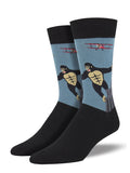 These are crew‑style socks featuring a classic New York City movie scene. The design shows King Kong, a black‑and‑white ape, with his arms outstretched as he clings to the gray Empire State Building. A small red bi‑plane appears nearby as if attacking, set against a light blue background.

The top band and foot of the socks are black. Made from a soft cotton‑nylon blend, the socks offer gentle stretch and detailed imagery, making them a fun and memorable New York City souvenir.
Sock size 10-13 fits U.S. men