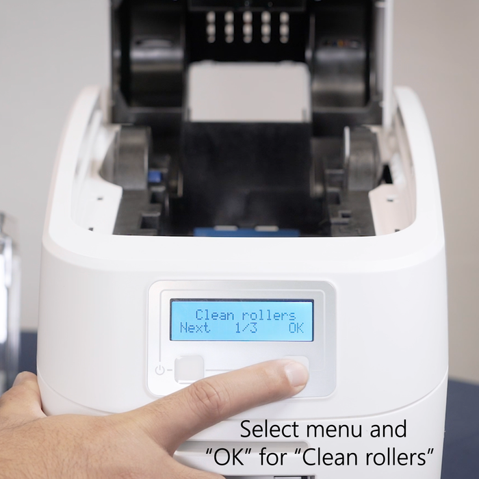 ID badge machine with digital display and hand selecting 'Clean rollers' option. Sold by Specialist ID.