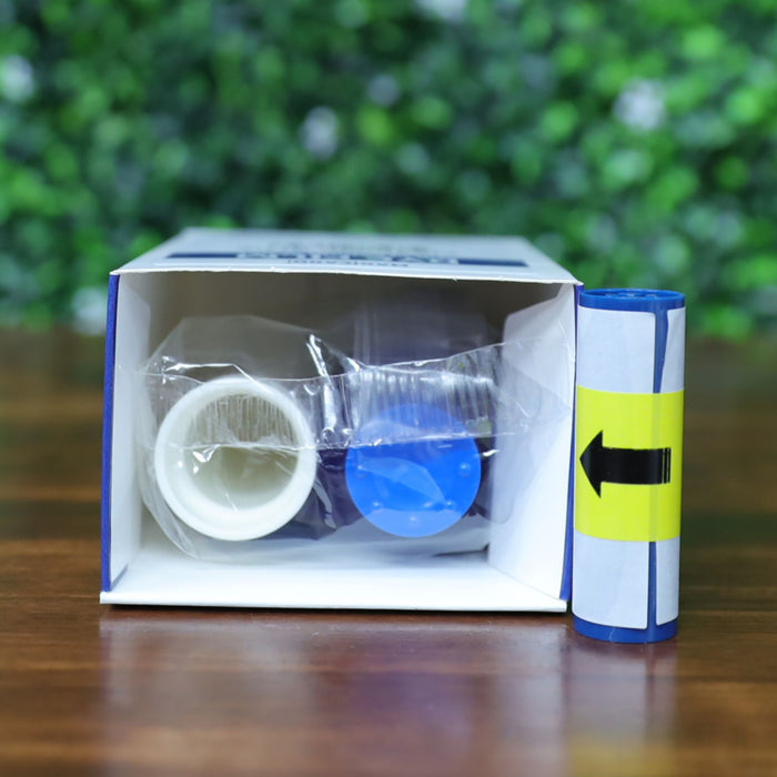 Magicard MA1000K-Blue ribbon cartridge and cleaning spool shown inside partially opened retail box with yellow directional label on wood surface and green foliage background. Photographed and sold by Specialist ID, an authorized Magicard dealer.
