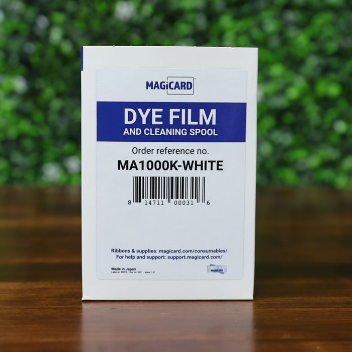 Front of the Magicard MA1000K-White Monochrome Ribbon box showing product label, barcode, and order reference number. The box includes dye film and cleaning spool for Magicard printers. Photographed and sold by Specialist ID, an authorized Magicard dealer.