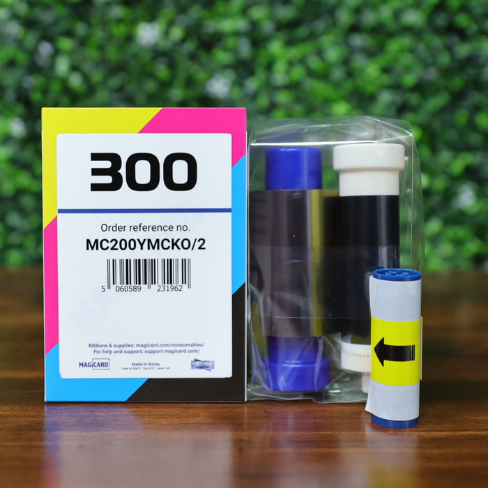 Front view of Magicard MC200YMCKO/2 dye film and cleaning spool kit for Magicard 300 printers. Packaging includes barcode, vibrant CMYK labeling, and the full ribbon and cleaning components visible in a sealed plastic pouch. Photographed and sold by Specialist ID, an authorized Magicard dealer.