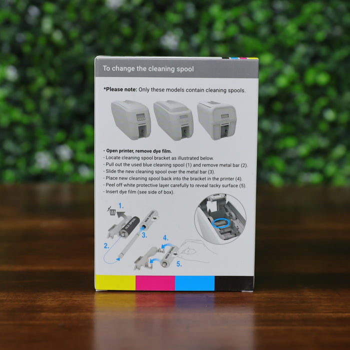 Back of Magicard MC200YMCKO/2 dye film ribbon kit box showing printer compatibility and illustrated step-by-step cleaning spool replacement instructions. Features color-coded graphic strip at the bottom and grayscale diagrams. Photographed and sold by Specialist ID, an authorized Magicard dealer.