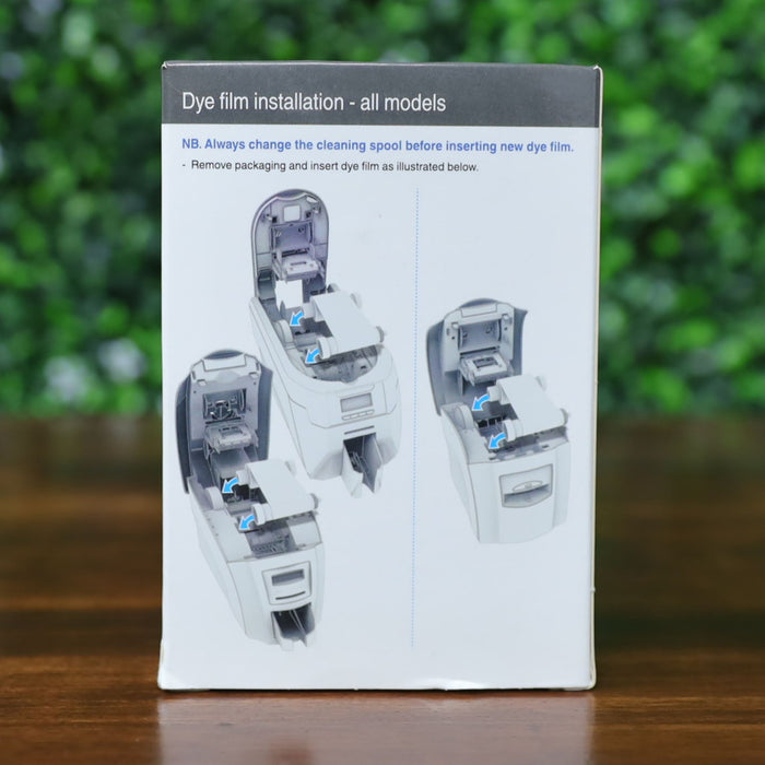 Back view of Magicard PR1000G dye film packaging displaying step-by-step dye film installation instructions for all printer models, with labeled diagrams and directional arrows. Photographed and sold by Specialist ID, an authorized Magicard dealer.