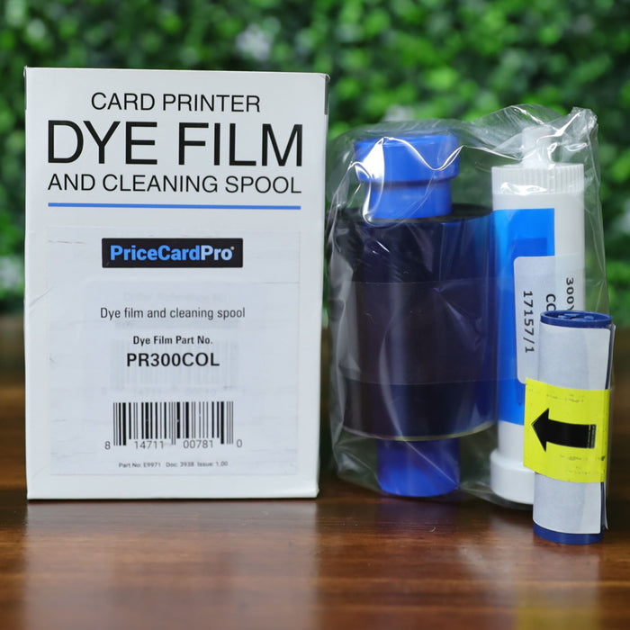 Front view of Magicard PR300COL YMCKO dye film and cleaning spool set. Box shows part number and barcode clearly labeled. Includes sealed YMCKO ribbon with visible magenta and yellow panels on blue and white spools, plus separate cleaning spool with yellow arrow label. Photographed and sold by Specialist ID, an authorized Magicard dealer.