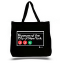 The image shows the museum’s full name in bold white block lettering centered across the bag, with bright red and green subway line circles and their route numbers below. A thick white border frames the design against a black background. The MTA logo appears in smaller type beneath the frame on the right.