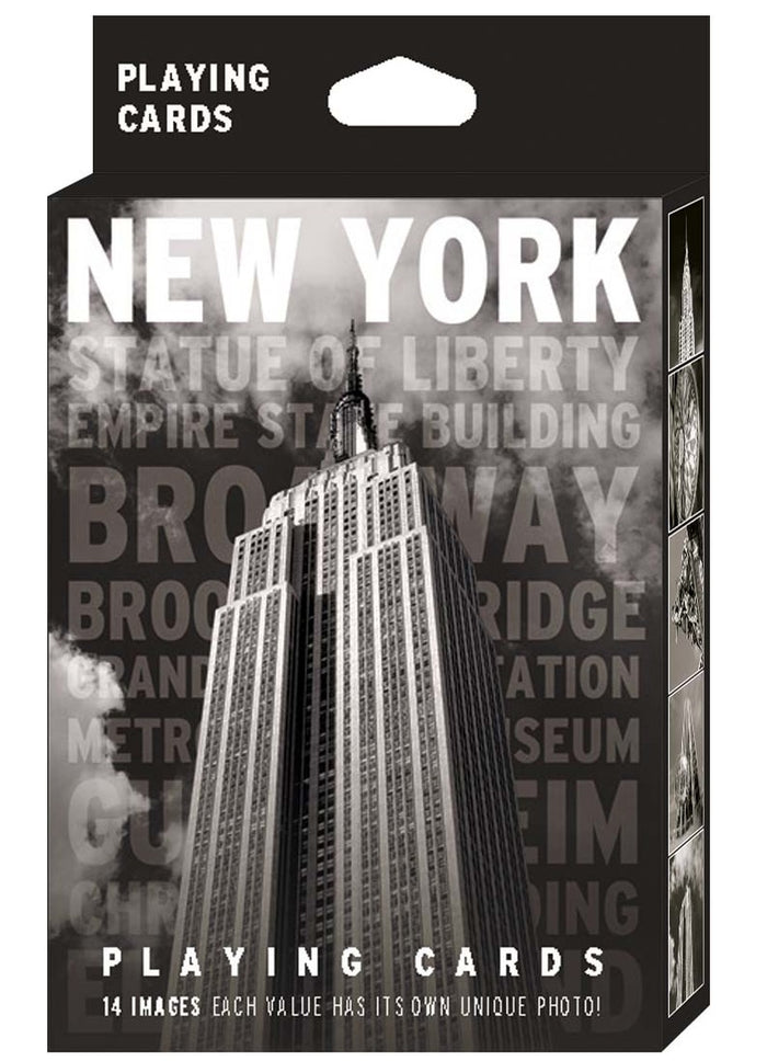 New York Black & White Playing Card Pack: The image shows the packaging for a high‑contrast black‑and‑white deck. The front displays a bold photograph of the Empire State Building with “NEW YORK” in large white capital letters at the top and faint grey landmark names beneath. “Playing Cards” appears in white at both the top and bottom. The side panels feature additional black‑and‑white images of iconic New York buildings.