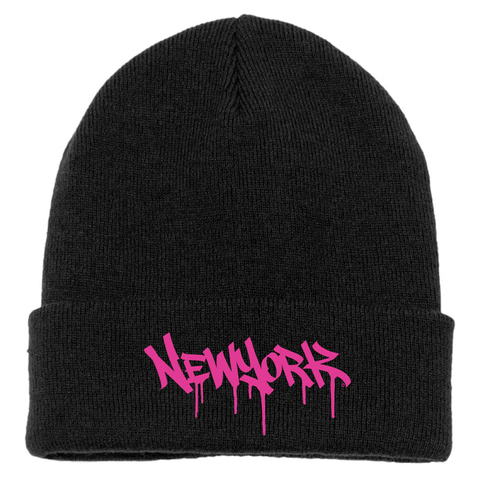 The image features a blavk acrylic knit cap with a folded cuff, accented by magenta pink melting block-letter text spelling “New York.”