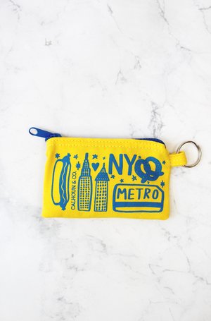 New York Screen Printed Coin Pouch, yellow background with blue line drawing: A small, soft fabric pouch with a smooth, flat surface and a zipper along the top edge. The pouch is rectangular and lightweight, easy to hold in one hand. The front is printed with bold, high‑contrast New York–themed graphics—clean shapes and simple lettering—with no raised textures. The fabric feels flexible but sturdy, designed to hold coins or small items securely.