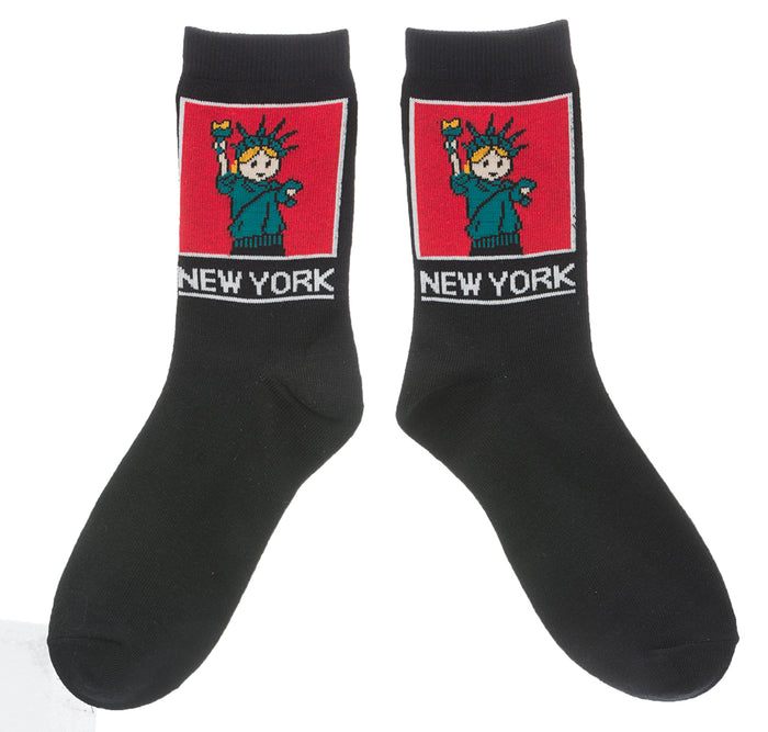 NYC Cartoon Statue of Liberty Socks 
These black crew socks feature a soft, woven cartoon image of the Statue of Liberty. On the ankle is a square red panel outlined in white, containing a friendly green Lady Liberty with small orange details in her hair and torch flame. Below the panel, “NEW YORK” appears in large, bold lettering in white. The socks feel smooth and flexible, made for comfortable everyday wear with playful New York character.