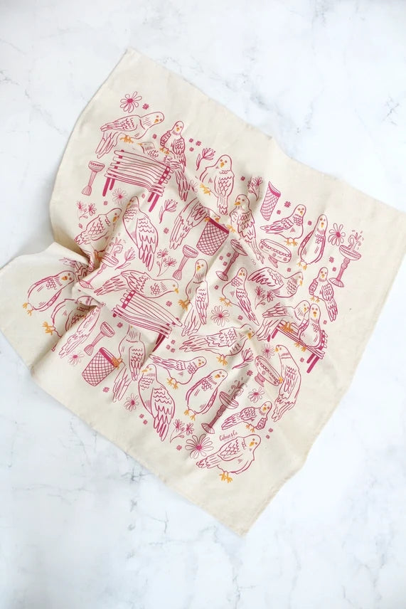 Park Pigeon Pals Screen Printed Tea Towel: This tea towel features a repeating pink and yellow line‑drawing pattern on a cream background, filled with small pigeon characters in charming park scenes—perched on a bench, splashing in a puddle, and wandering by a trash can.
