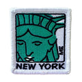 A square embroidered patch featuring a stylized green Statue of Liberty face with black outlines, a white border, and the word "NEW YORK" in black at the bottom.