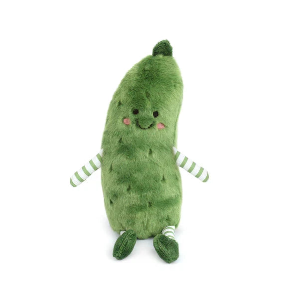 The image features the Pickle Plushie, which has a soft, velvety texture with a gentle squish when squeezed. It’s bright green with darker stitched details that suggest pickle bumps. Its simple embroidered face—small eyes, a curved smile, and pink cheeks—gives it a friendly, cheerful expression, and its smooth, rounded shape makes it easy and comforting to hold.