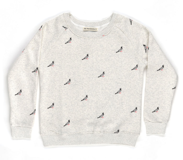 This unisex crew neck sweatshirt is made from soft, breathable fabric and feels smooth and comfortable on the skin. It has a relaxed fit with a round neckline, long sleeves, and gently ribbed cuffs and hem. The surface is covered in a repeating illustration of pigeons in shades of grey, with small pink feet adding contrast, giving the garment a playful, city‑inspired character.
