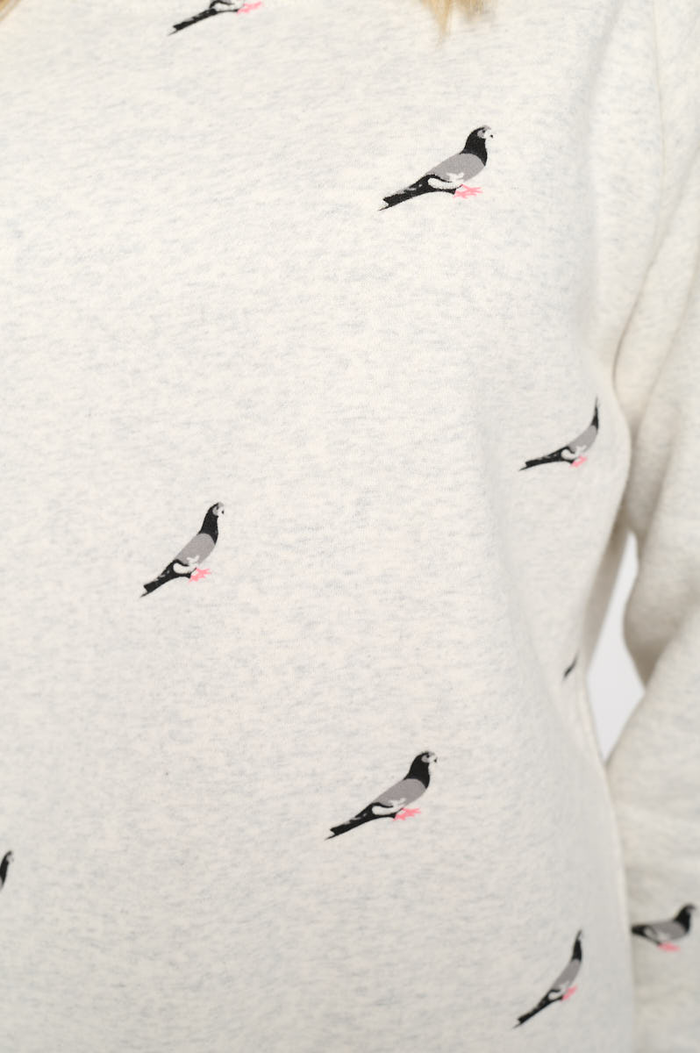 The image shows a repeating pigeon motif in soft shades of gray with pink feet, printed on a heather‑gray sweatshirt fabric.