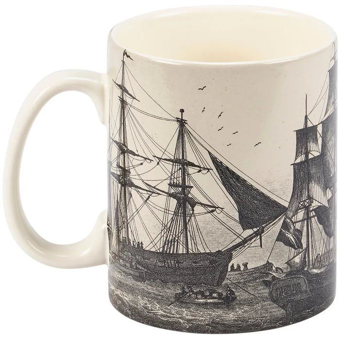 The image features the Schooner Mug, a durable 18‑ounce stoneware mug with a smooth, weighty feel, a comfortable curved handle, and a distinctly vintage look, featuring a full wrap‑around design of old‑fashioned sailing ships crossing ocean waves in soft gray tones on an off‑white, sepia‑style background; it stands about 5¼ inches tall and is safe for the microwave, oven, and dishwasher.