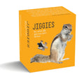 A bright yellow Jiggies puzzle box featuring a photo of a squirrel, with one eye shaped like a jigsaw piece. On the left, “JIGGIES” appears in large, thin black letters, with the tagline “for when life gets too darn serious” printed beneath.