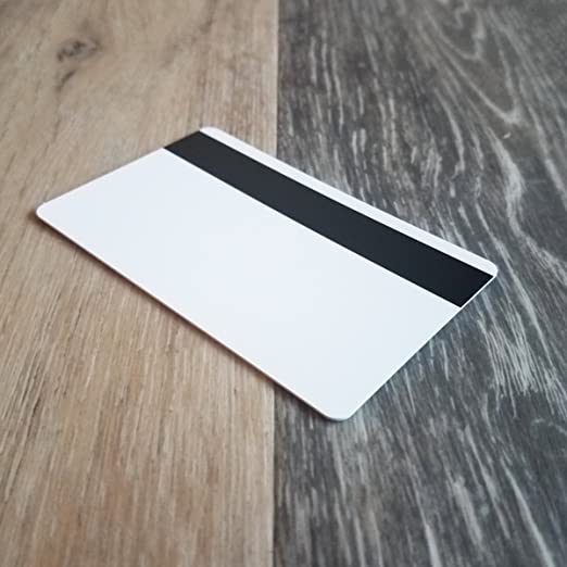 A high quality Standard CR80 30mil Card w/ HiCo Mag Stripe lies on a wooden surface. Sold by Specialist ID.