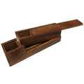 Rectangular traveling writing instrument box made of smooth teak wood, shown open. The warm brown wood has visible grain and a simple, sturdy construction. The box is shaped to hold a square glass inkwell and a wooden nib pen (not included), designed to keep writing tools neatly contained and easy to carry. The overall feel is solid, refined, and reminiscent of historic travel writing kits.