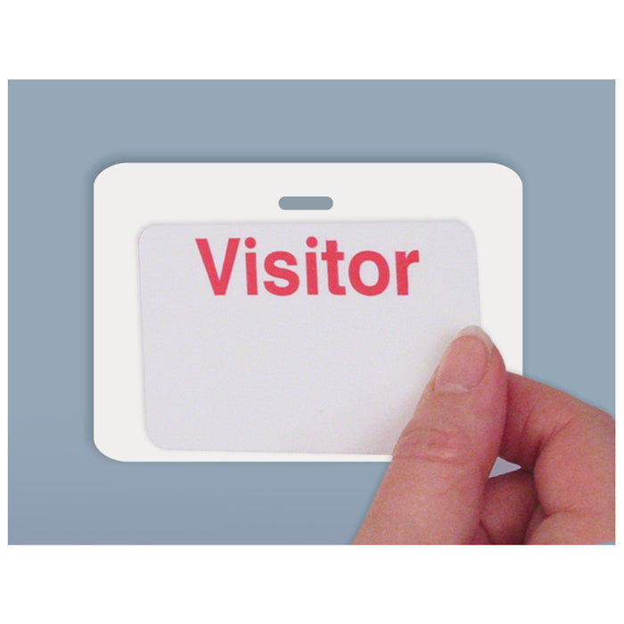 A hand is holding a white badge with the word "Visitor" in red letters, placed against a blue background. The badge is attached using a Reusable 4 X 3 Cardbacker Badge Back, Box of 500 (P/N 05661), ensuring it stays securely in place.