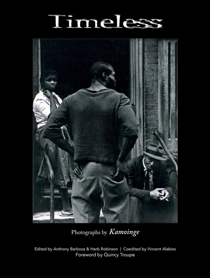Book title: Timeless. The cover features a minimalist black‑and‑white photograph of a woman and two men at the entrance of a New York building stoop. The book’s title appears blurred and above the image.