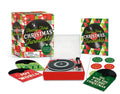 Product title: Tiny Holiday Turntable, Includes 3 Mini-LPs to Play. The image features a miniature holiday-themed turntable packaged in a whimsical red‑and‑green box. Three mini LPs are included, each with its own small illustrated album cover. The records play “We Wish You a Merry Christmas,” “Joy to the World,” and a third jazzy winter instrumental track.